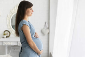 Mulher grávida olhando a janela