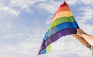 Homem segurando bandeira do orgulho gay